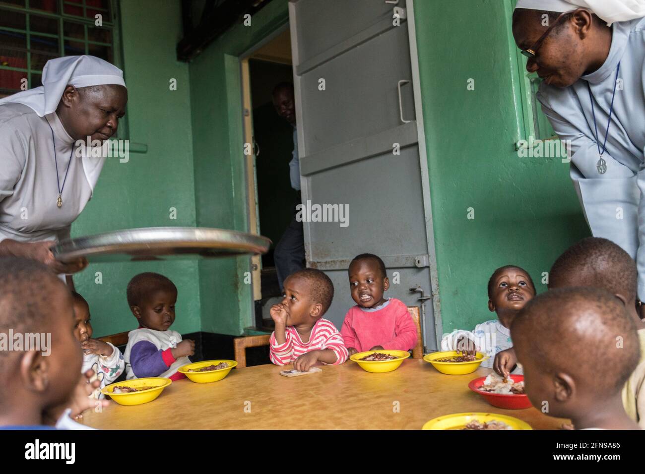 Nonnen servieren Mittagessen im St. Kizito Waisenhaus in ländlichen Gebieten Ostuganda Stockfoto