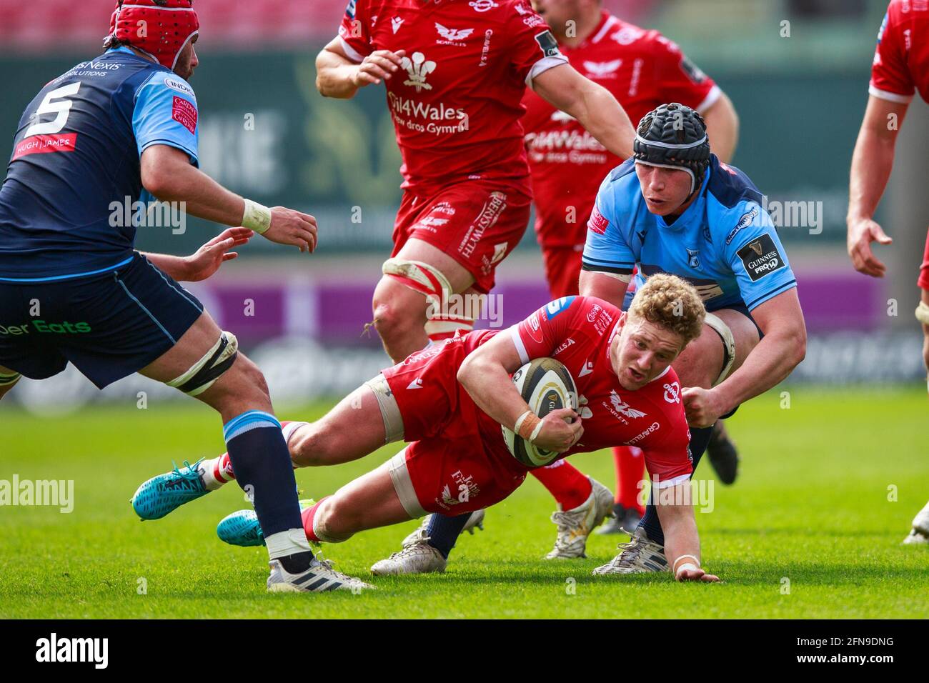 Llanelli, Großbritannien. 15. Mai 2021. Scarlets Fly Half Angus O’Brien wird während des Scarlets gegen Cardiff Blues PRO14 Rainbow Cup Rugby Match angegangen. Kredit: Gruffydd Thomas/Alamy Live Nachrichten Stockfoto