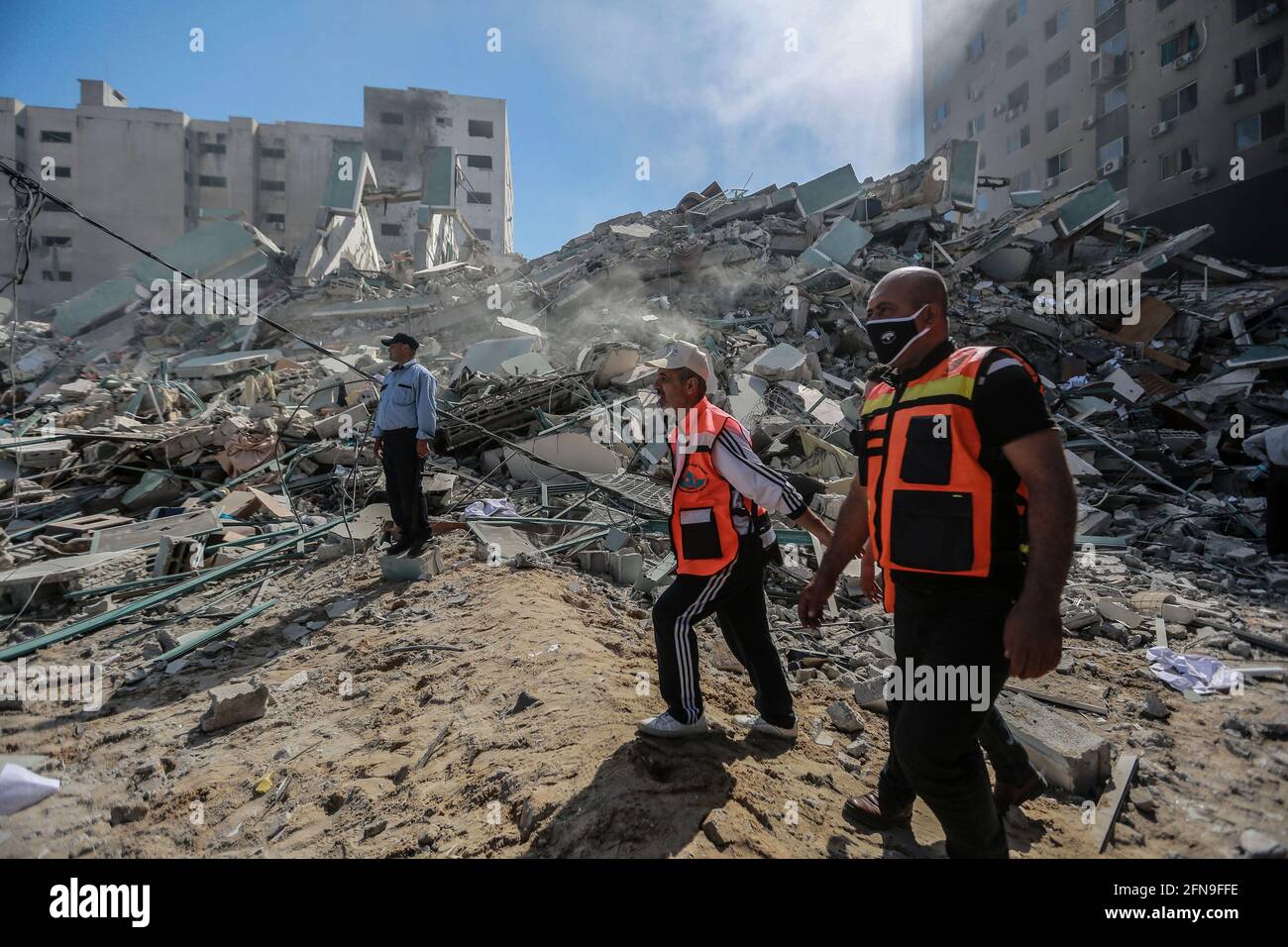 Gaza-Stadt, Palästinensische Gebiete. Mai 2021. Palästinensische Sanitäter inspizieren die Überreste des Al-Jalaa-Turms, in dem mehrere Medien, darunter die Associated Press und Al Jazeera, untergebracht waren, nachdem er von einem israelischen Luftangriff inmitten der eskalierenden Eskalation der israelisch-palästinensischen Gewalt getroffen wurde. Kredit: Mohammed Talatene/dpa/Alamy Live Nachrichten Stockfoto