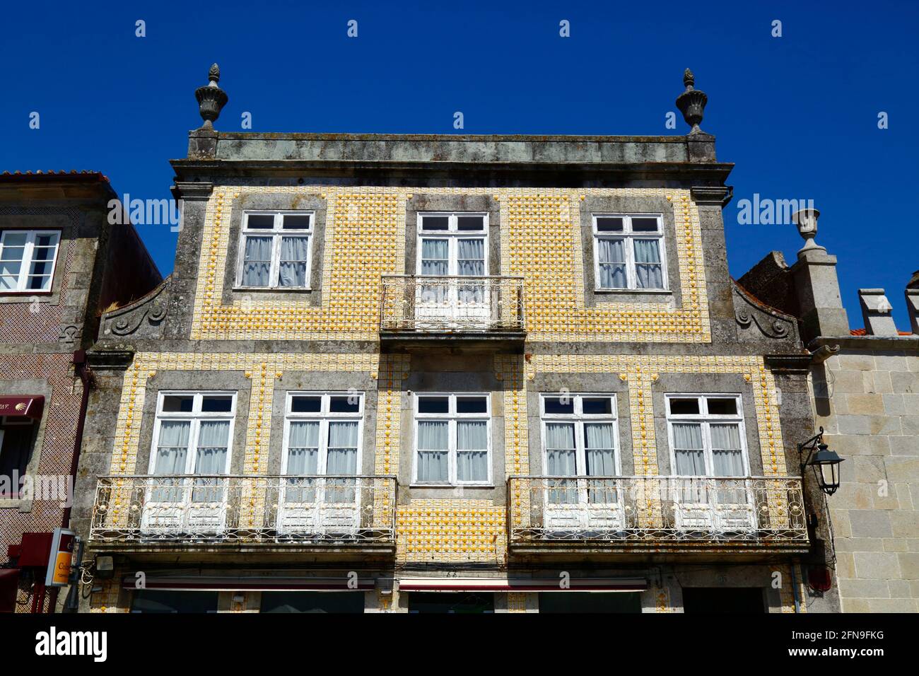 Obere 2 Etagen des Gebäudes mit Fassade aus gelben Keramikfliesen auf dem Hauptplatz von Praça Conselheiro Silva Torres, Caminha, Provinz Minho, Portugal Stockfoto