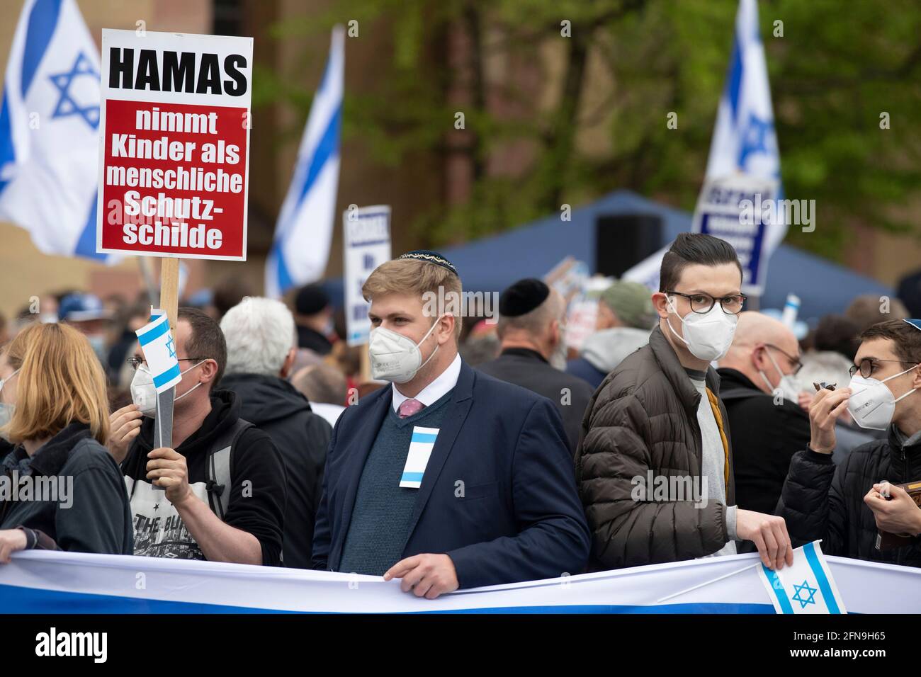 Frankfurt, Deutschland. 15. Mai 2021: Ein Teilnehmer einer pro-israelischen Kundgebung hält ein Zeichen: „die Hamas nimmt Kinder als menschliche Schutzschilde an“. Die Organisatoren wollen die Demonstration nutzen, um auf die aktuelle Situation im Nahen Osten aufmerksam zu machen. Foto: Boris Roessler/dpa Quelle: dpa picture Alliance/Alamy Live News Stockfoto