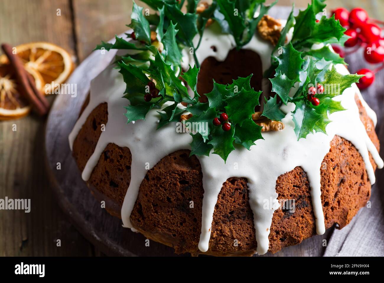 Weihnachts-Schokoladenkuchen mit weißer Vereisung und Granatapfelkernen auf Ein dunkler Hintergrund aus Holz Stockfoto