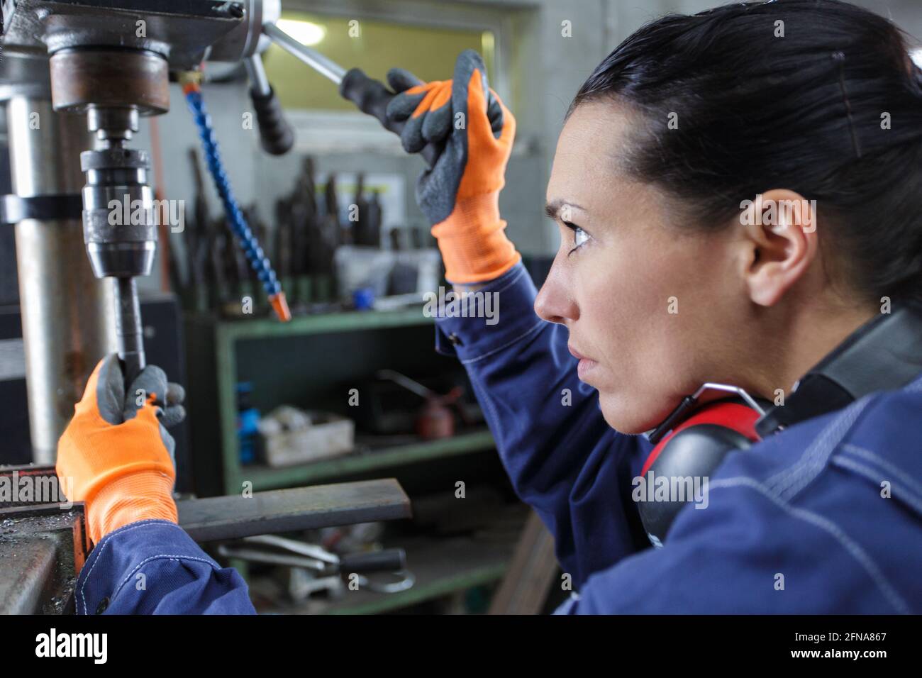 Fabrikarbeiterin, die mit Elektrobohrmaschine arbeitet Stockfoto