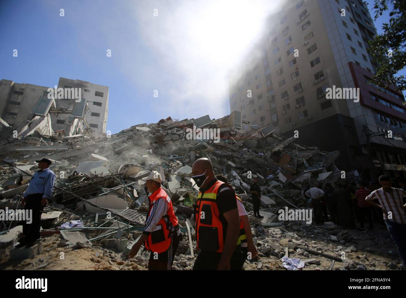 Gaza, Gaza. Mai 2021. Die Feuerwehrleute gehen nach einem israelischen Luftangriff im Gazastreifen am 15. Mai 2021 zu den Trümmern des Jala-Turms, in dem internationale Pressebüros untergebracht waren. - ein israelischer Luftangriff zerstörte das 13-stöckige Gebäude, in dem das in Katar ansässige Al-Jazeera-Fernsehen und die amerikanische Nachrichtenagentur The Associated Press im Gazastreifen untergebracht sind. Foto von Ahmad Zaqut/UPI Credit: UPI/Alamy Live News Stockfoto