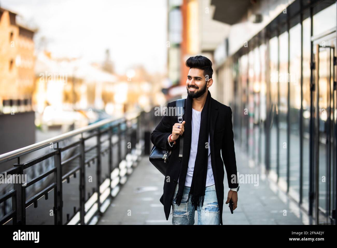 Porträt eines jungen asiatischen Mannes in legerer Kleidung mit Rucksack auf dem Hintergrund der urbanen Szene. Stockfoto