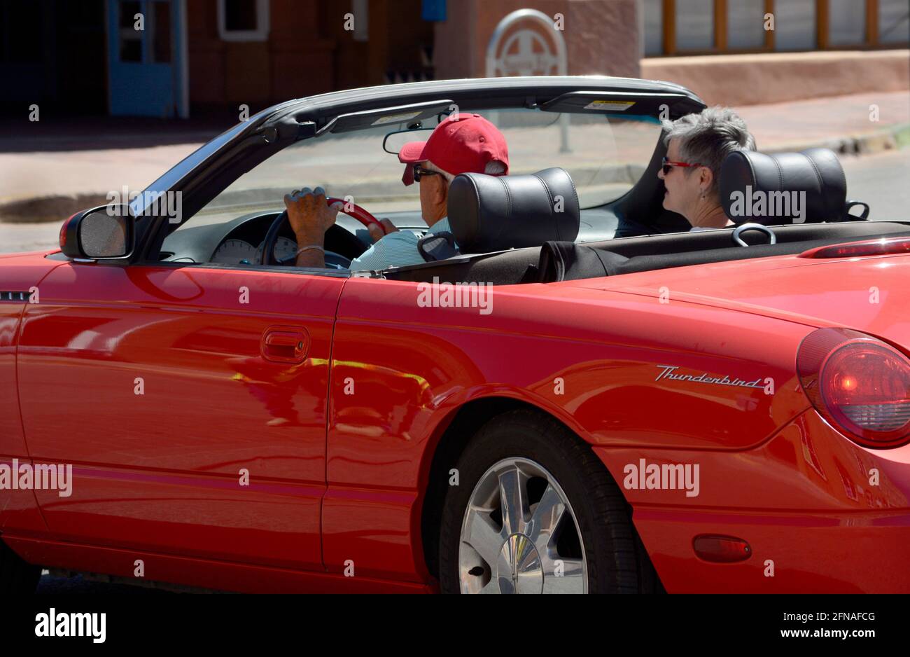 Ein älteres Paar, das aus Texas nach Santa Fe, New Mexico, reist, genießt die Besichtigung in ihrem roten Thunderbird Cabrio. Stockfoto