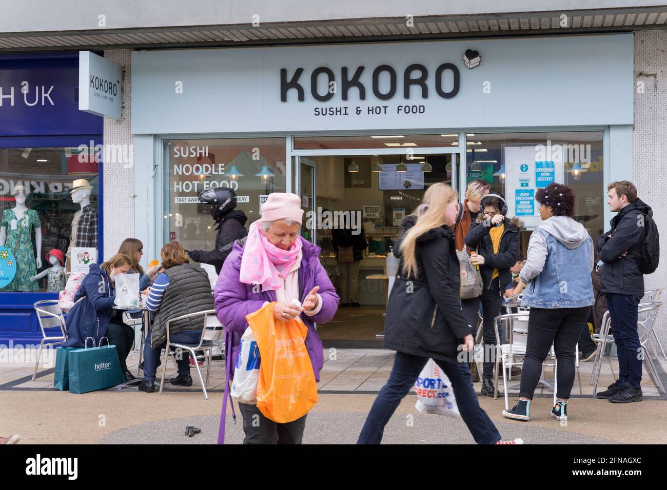 Kunden, die außerhalb des Kokoro Sushi and Hot Food Restaurants in Bromley High Street, kent, England, essen Stockfoto