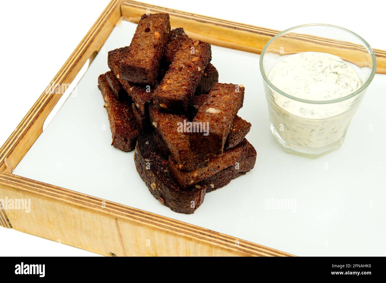 Brotsnack mit schwarzem Knoblauch. Gebratene Knoblauchkröten auf weißem Betontisch. Isolieren auf weißem Hintergrund. Stockfoto
