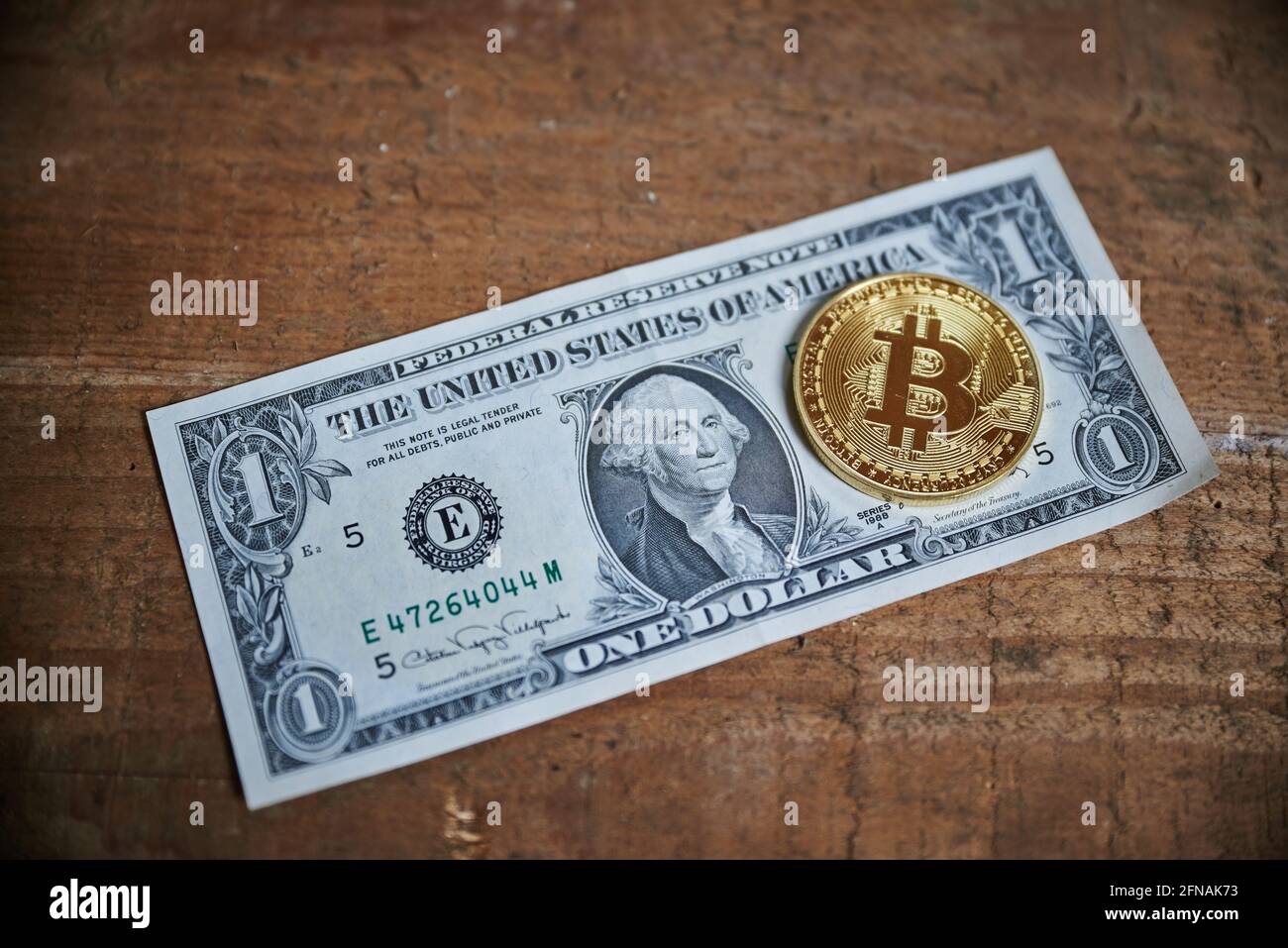 Nahaufnahme einer goldenen Bitcoin-Medaille auf einem 1-Dollar-Schein. Stockfoto