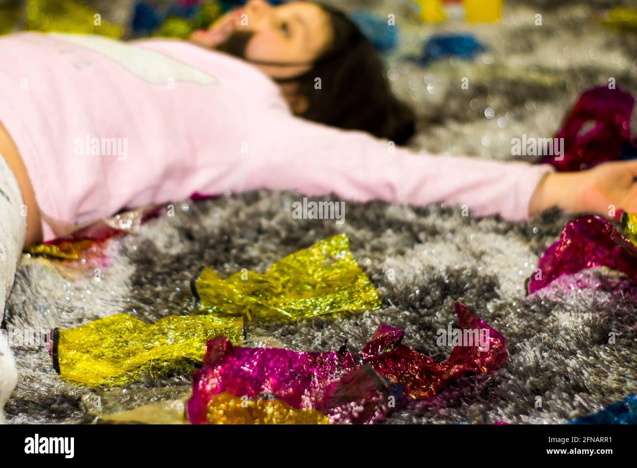 Glückliche junge Kinder, die auf dem Boden in der Nähe von bunten Druckfarben gelb und rosa liegen, Lebensfreude, spielende Kinder Stockfoto