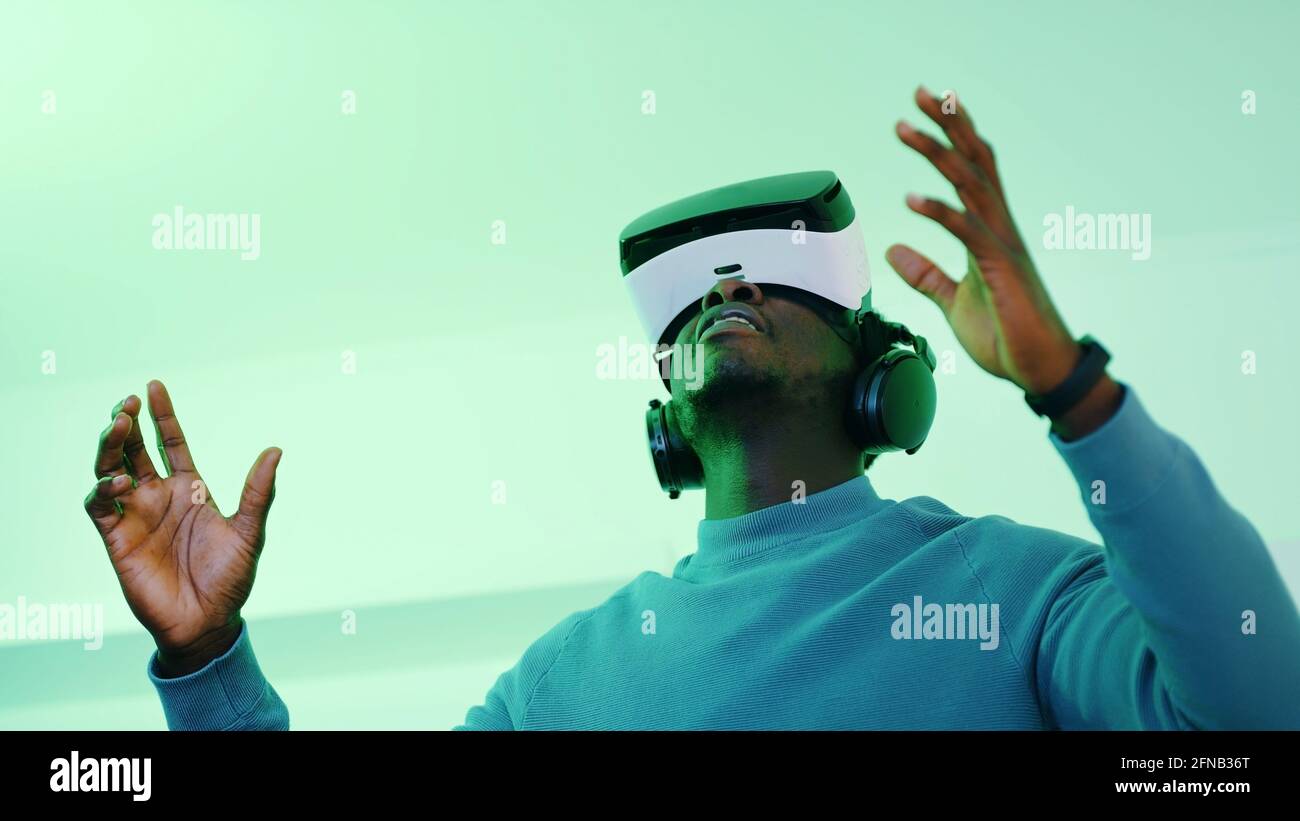 Mann, der eine Virtual Reality Brille trägt und die virtuelle 360-Grad-Umgebung genießt. Hochwertige Fotos Stockfoto