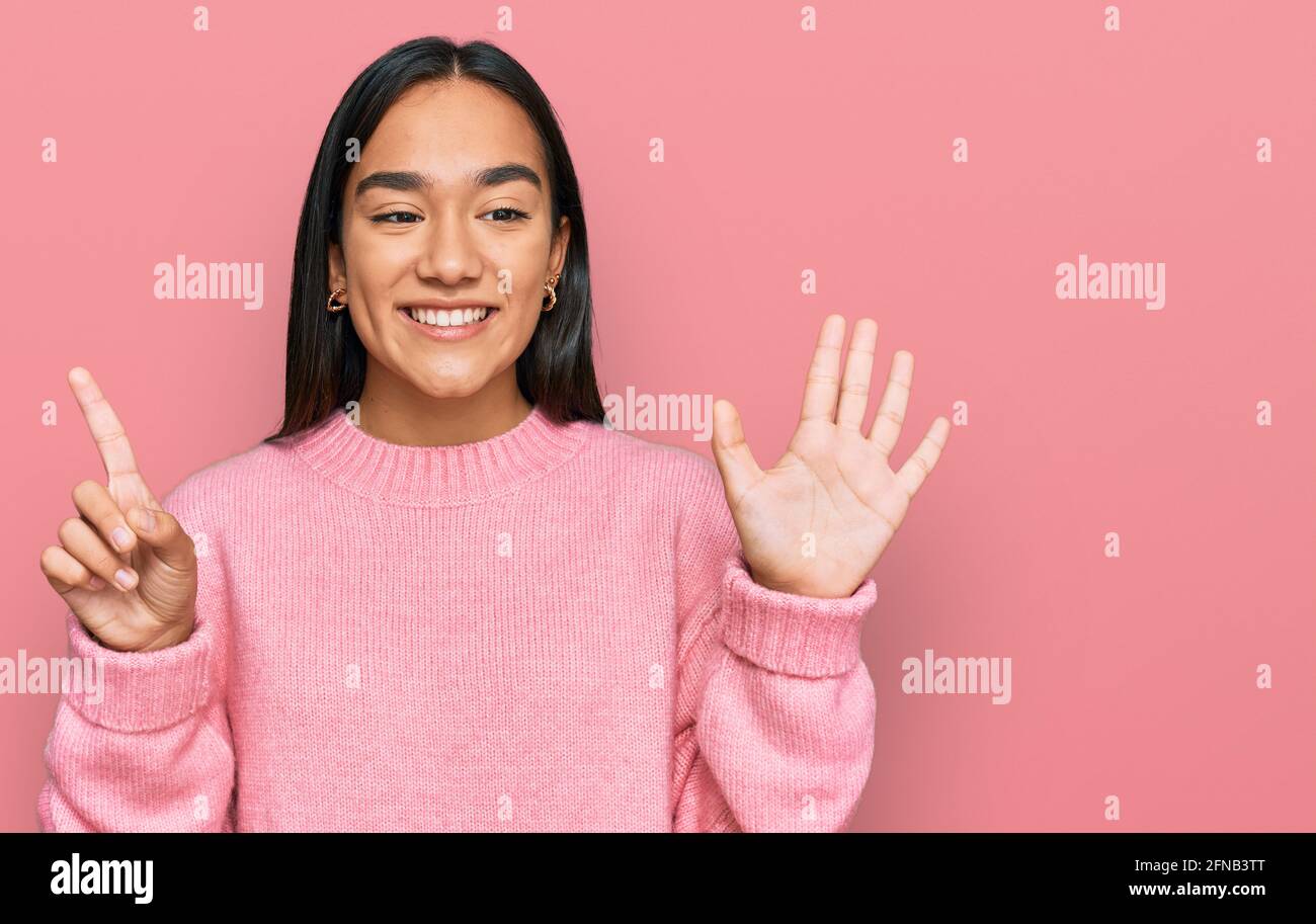 Junge asiatische Frau trägt lässige Winter Pullover zeigen und zeigen mit den Fingern Nummer sechs, während lächelnd zuversichtlich und glücklich. Stockfoto