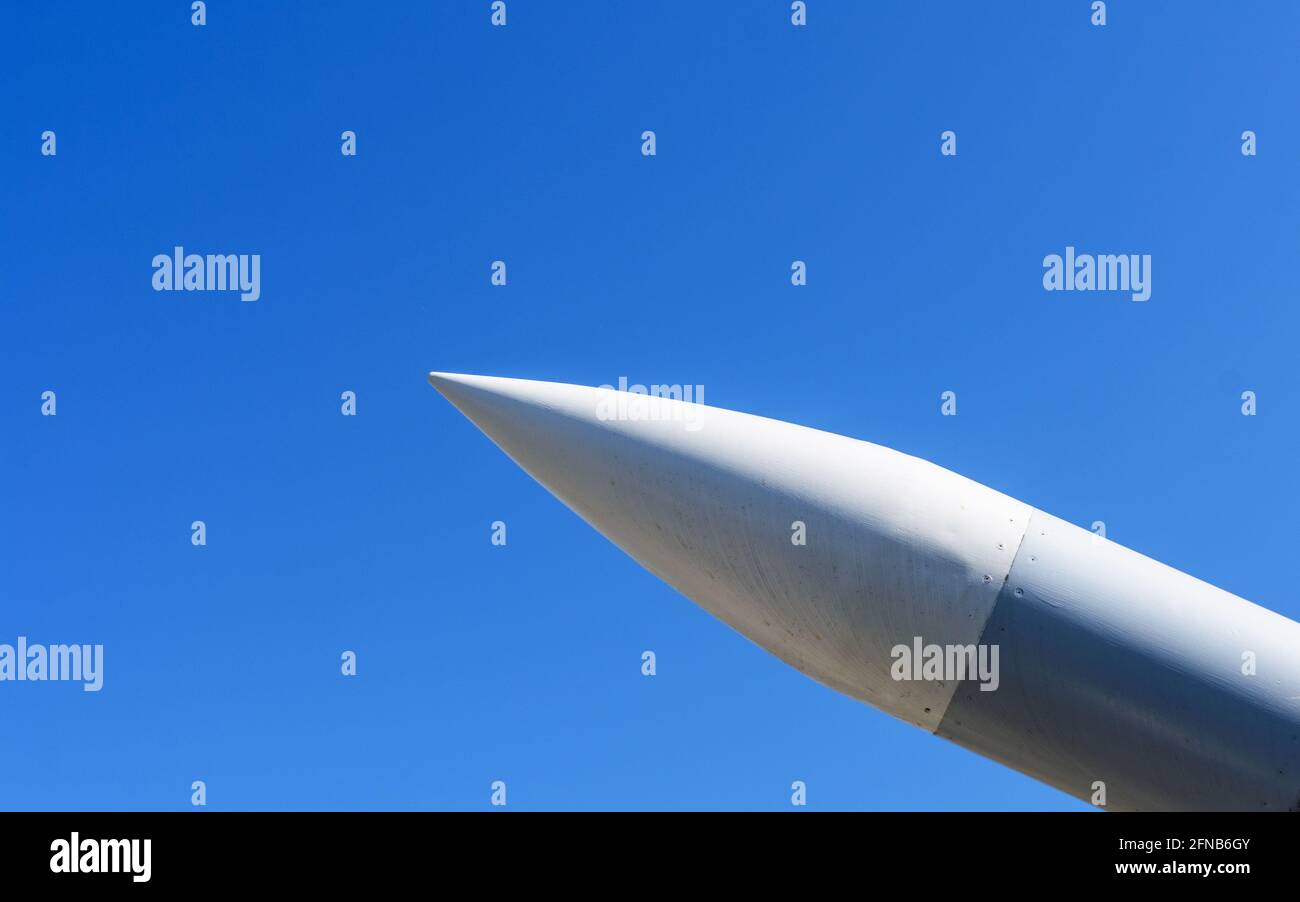 Rakete mit einem Sprengkopf, der im Sonnenlicht auf den blauen Himmel zeigt. Nahaufnahme. Stockfoto