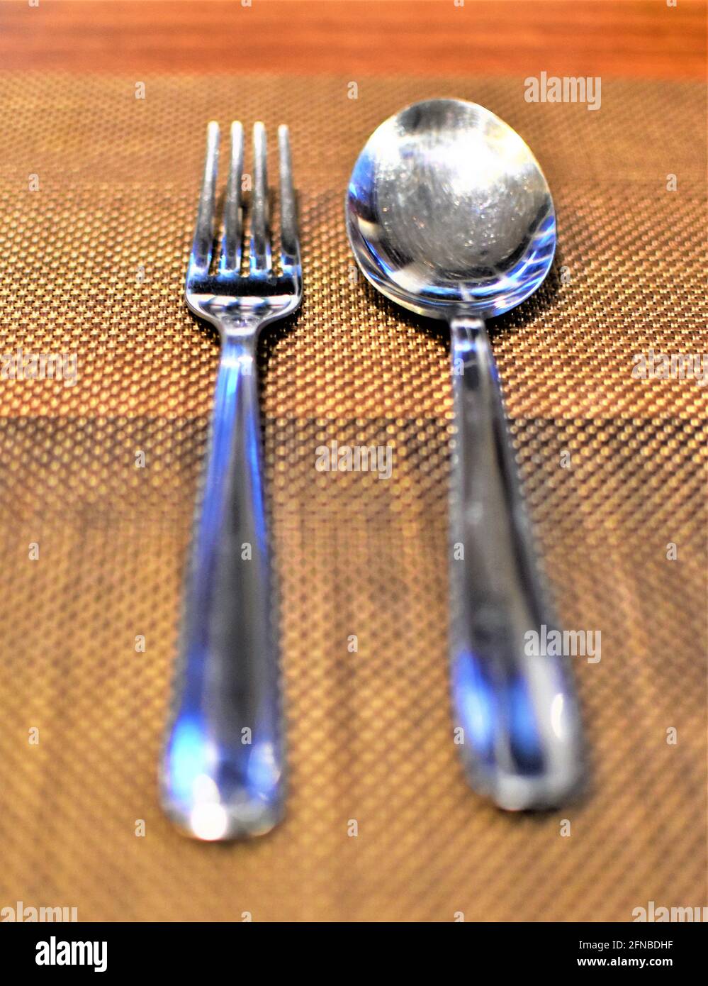 Eine Gabel und ein Löffel Besteck ordentlich auf einem Holztisch angeordnet Stockfoto