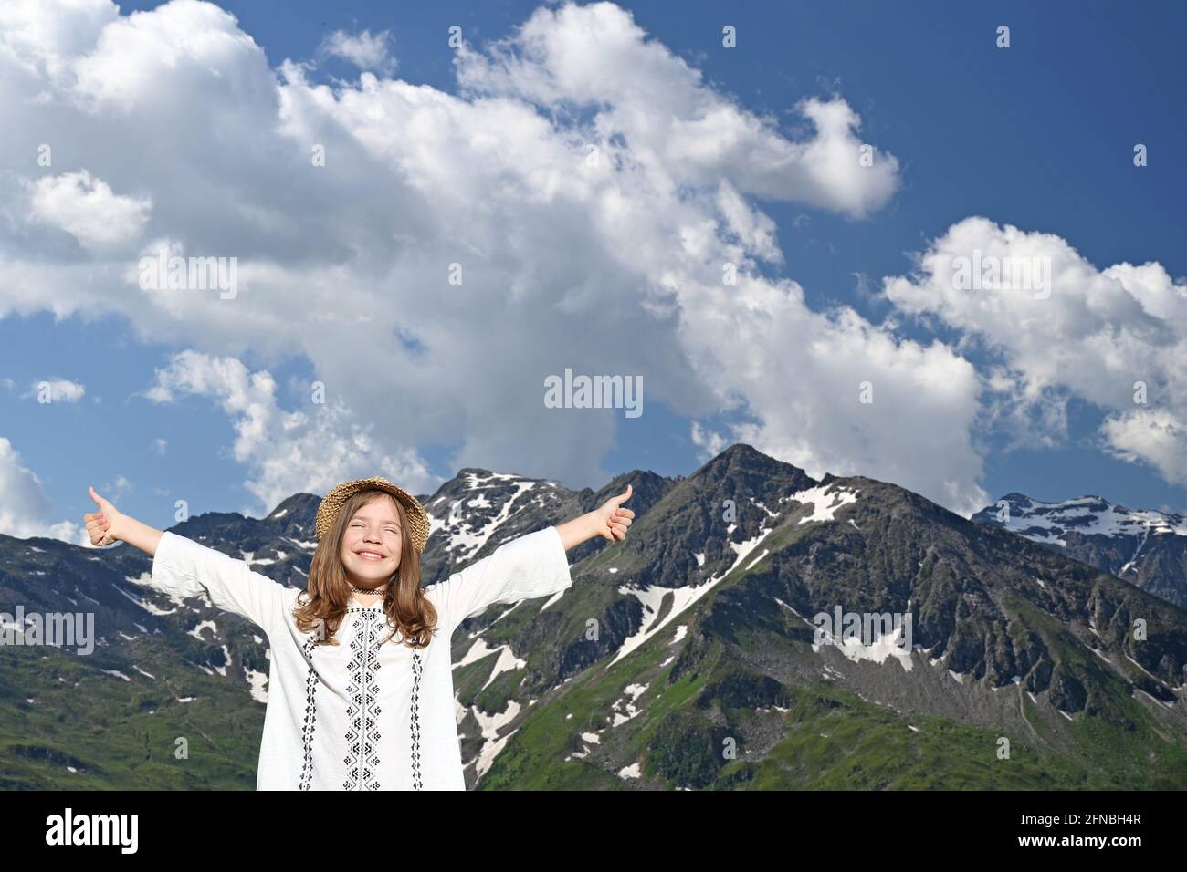 Glückliche kleine Mädchen mit Daumen oben auf dem Berg Stockfoto