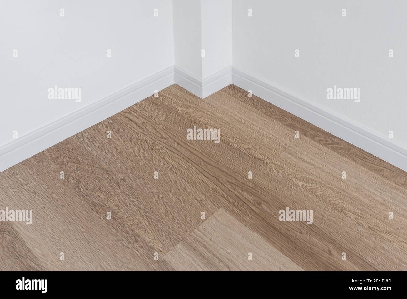 Holzfußboden mit weißer Wand Stockfoto