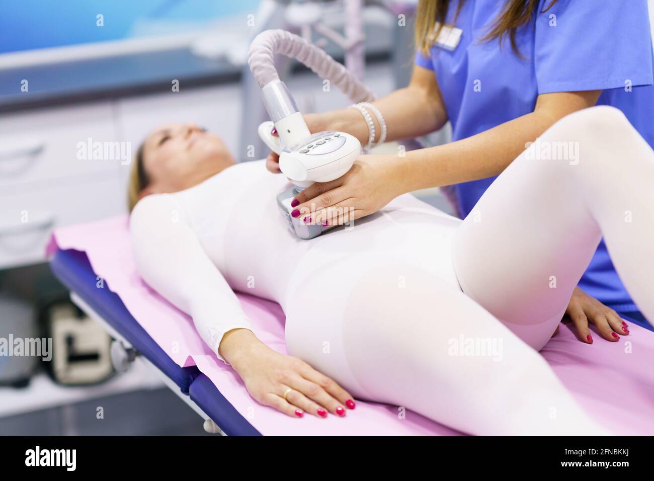Frau im Spezialanzug mit einer Anti-Cellulite-Bauchmassage Mit Spa-Gerät  Stockfotografie - Alamy