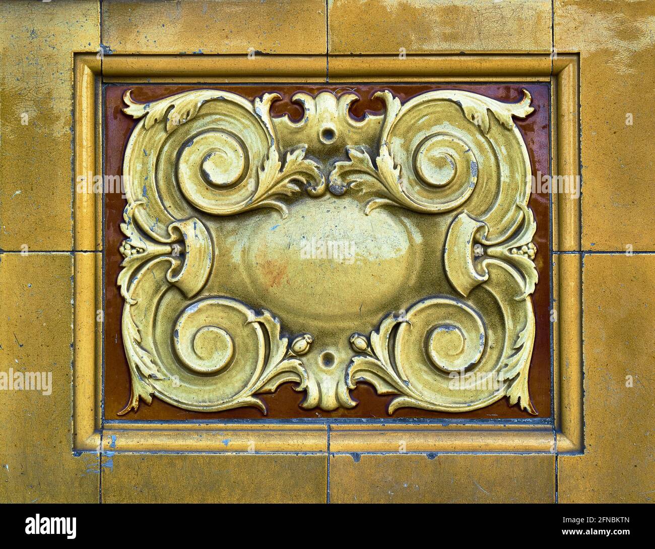Detail von aufwendigen und dekorativen Keramikfliesen in Gelbgold Und warmes Braun Stockfoto