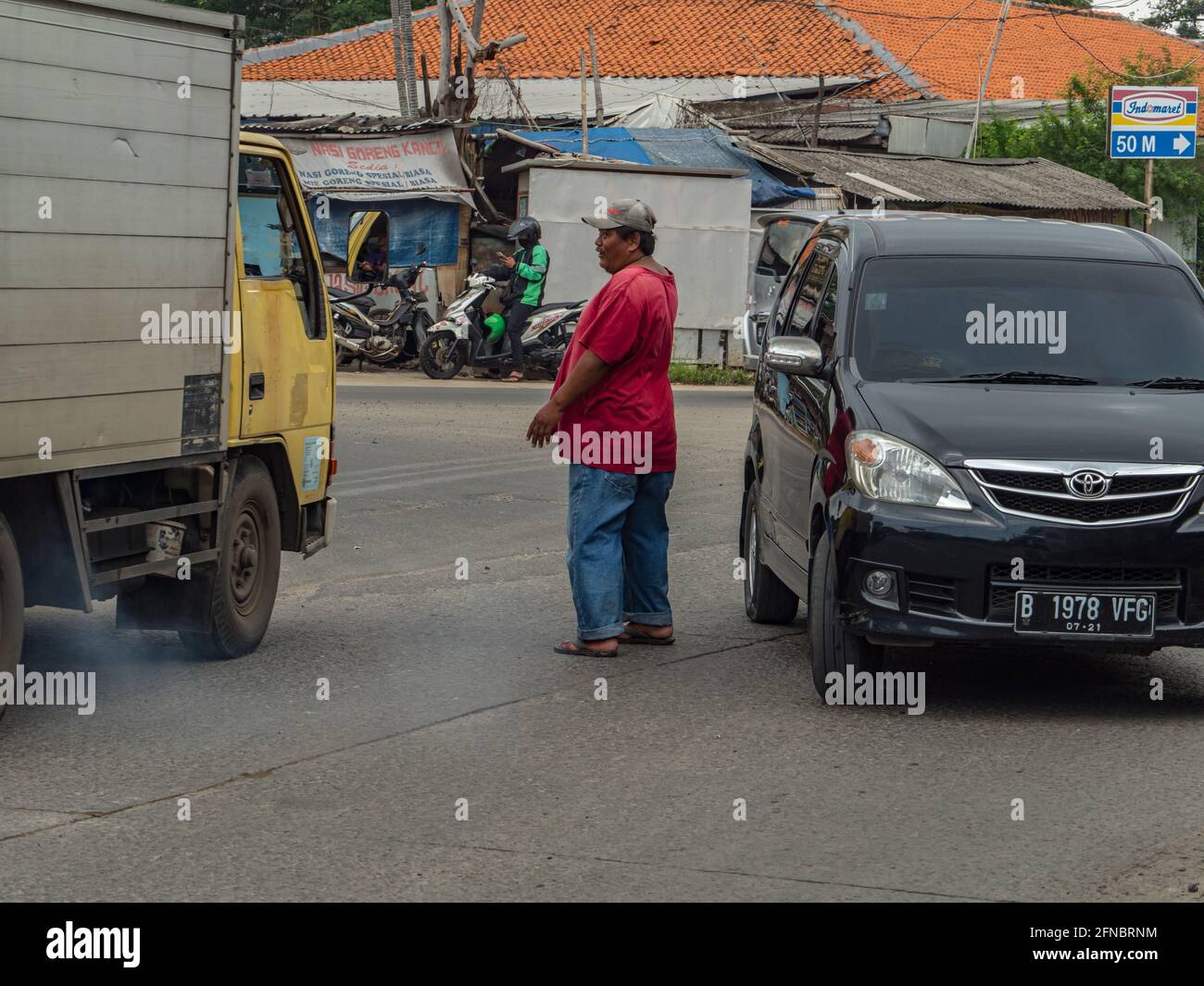 Jakarta, Indonesien - 20. Februar 2018: Lokaler Mann lenkt den Verkehr während der Hauptverkehrszeit auf einer Straße in Jakarta. Asien. Stockfoto
