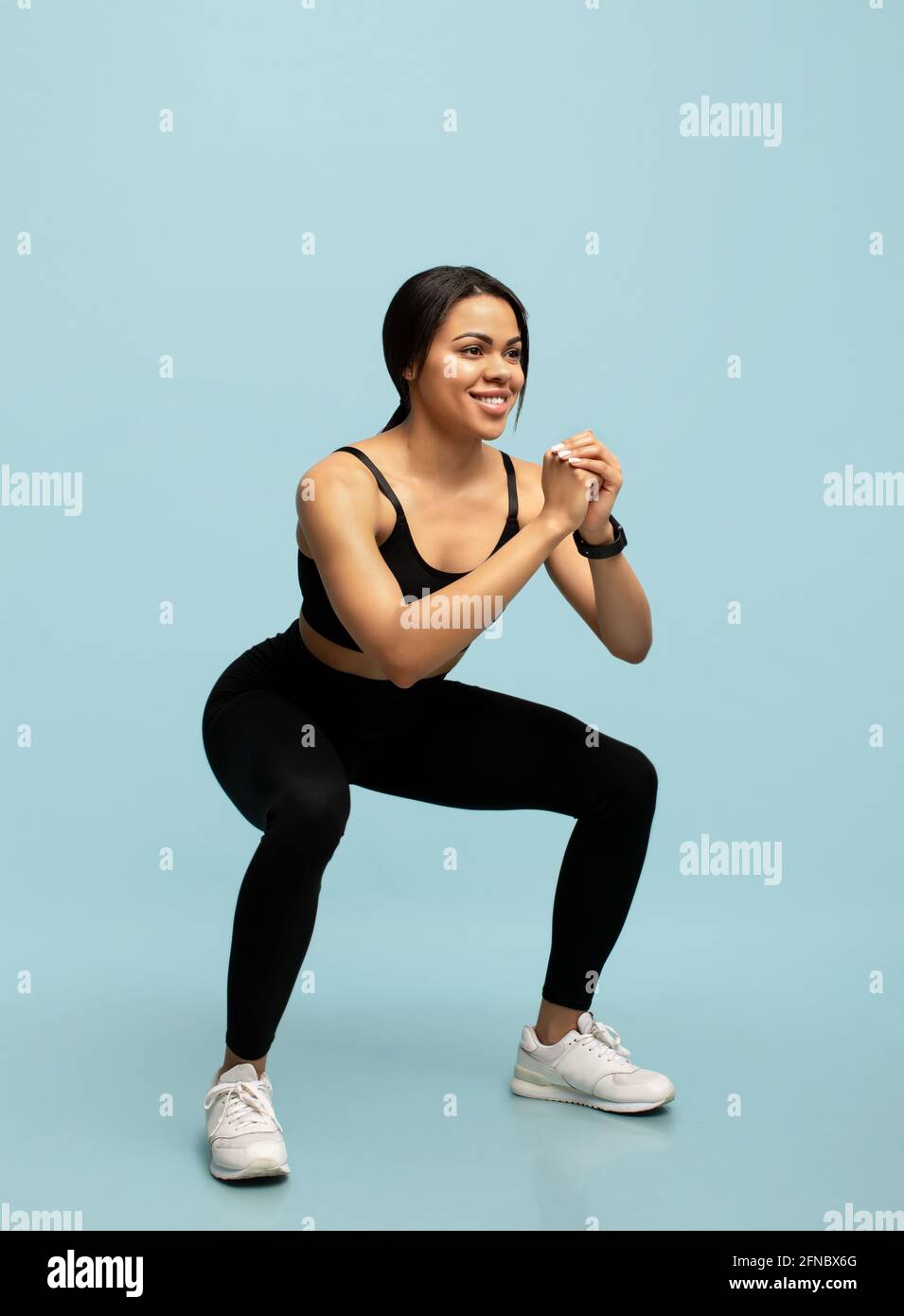 Fitness Und Sportconcpet Fit Schwarze Dame In Sportbekleidung Tun Tiefe Kniebeugen Ubung Wahrend Des Trainings Auf Blauem Hintergrund Stockfotografie Alamy