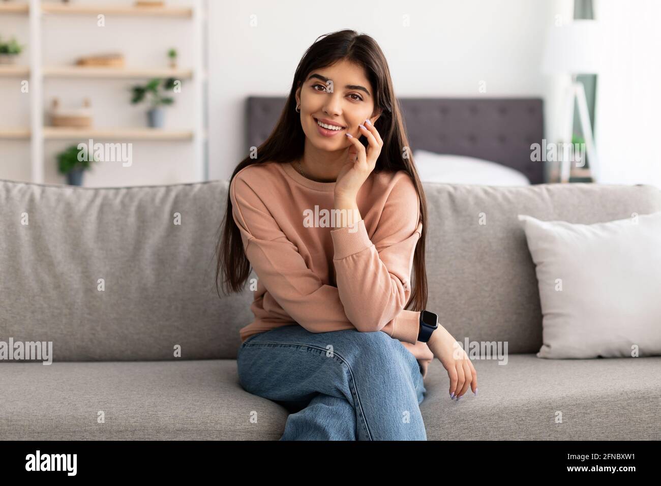 Porträt einer jungen Frau, die lächelt und vor der Kamera posiert Stockfoto