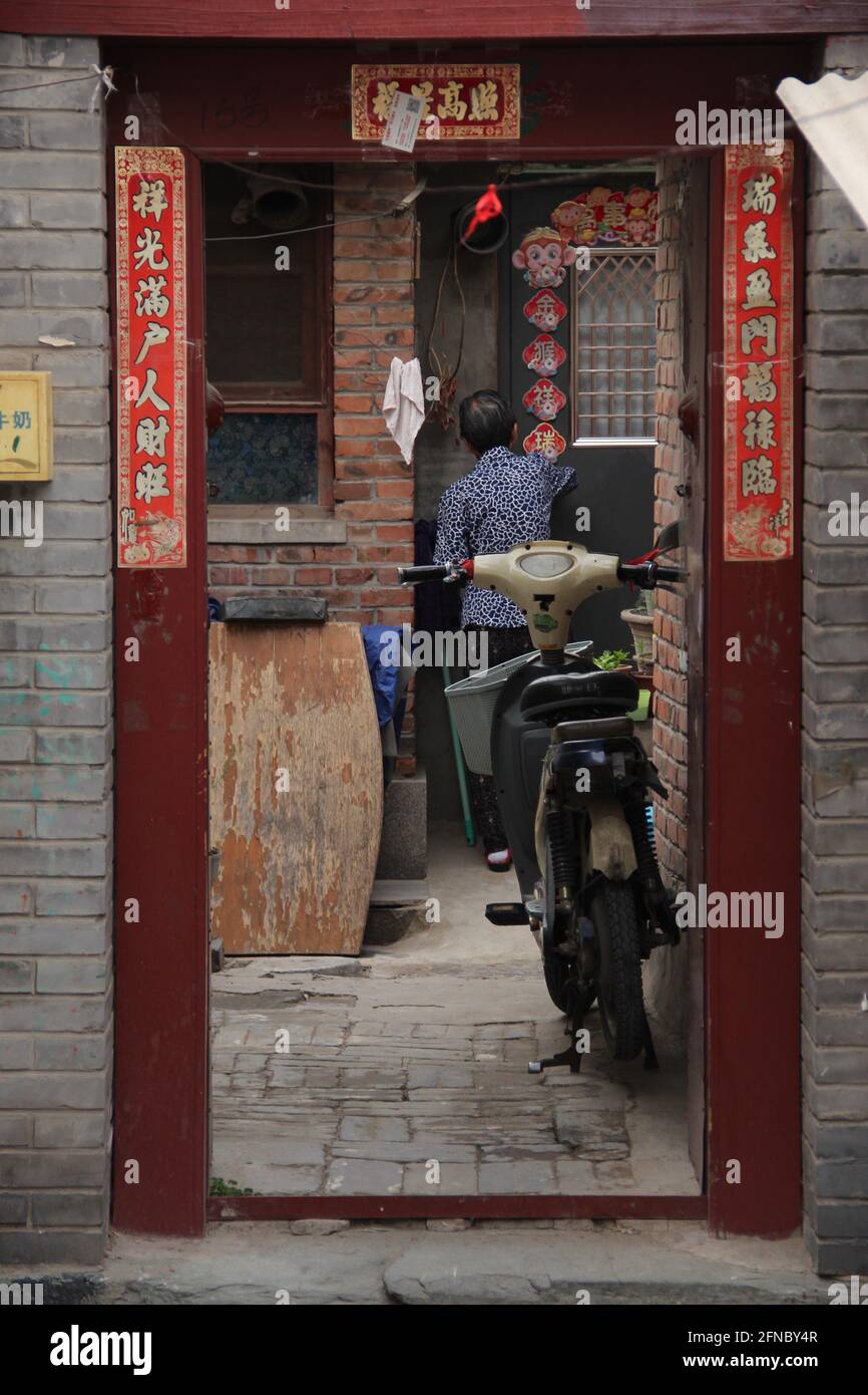 Ein alter Mann kommt in einem Hutong in Peking, China, in sein Haus Stockfoto