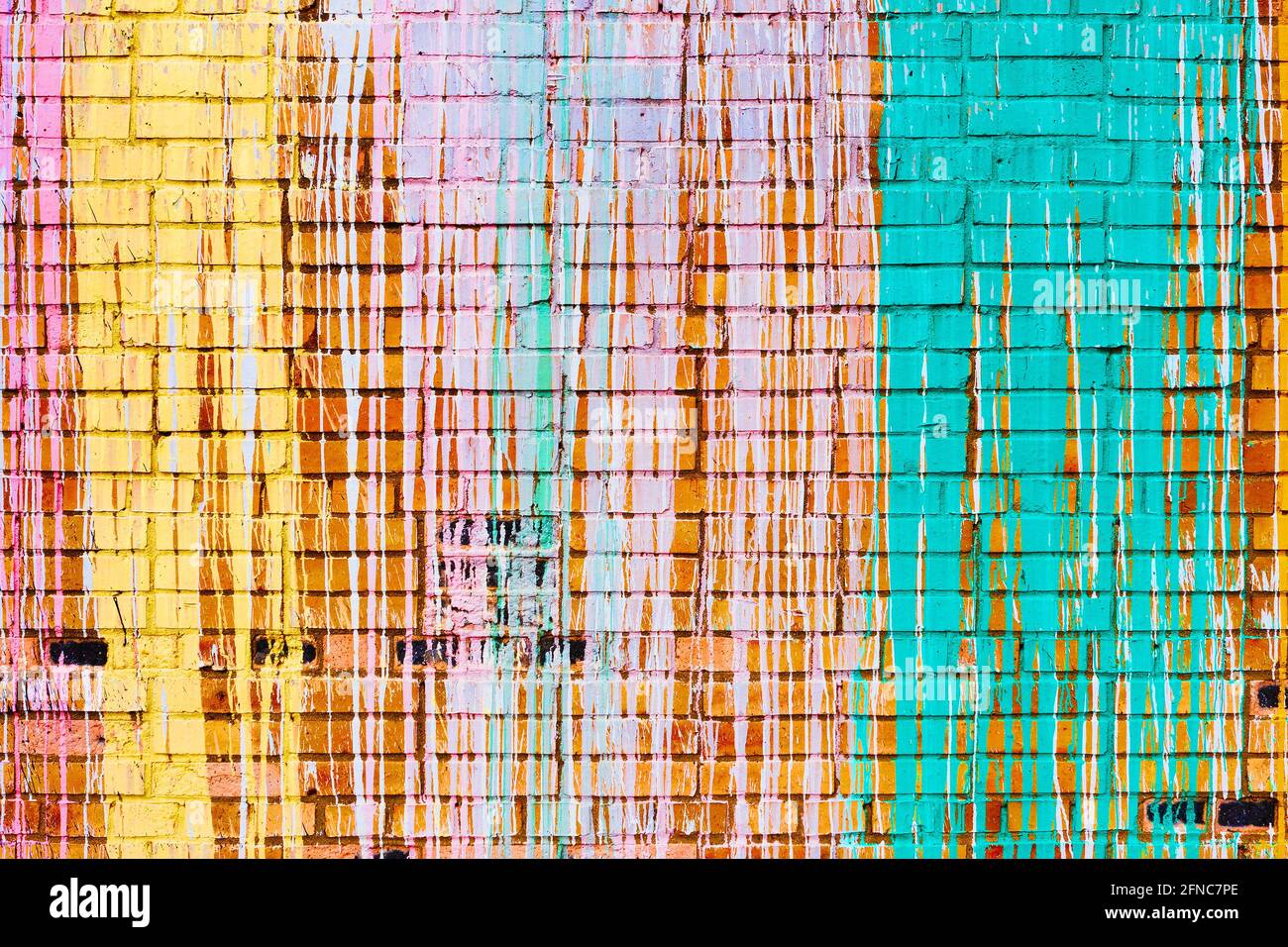 Ziegelwand mit bunten Farbtropfen. Stockfoto