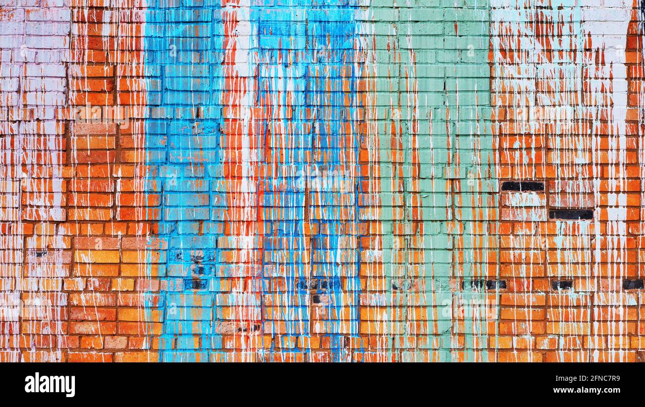 Ziegelwand mit bunten Farbtropfen. Stockfoto