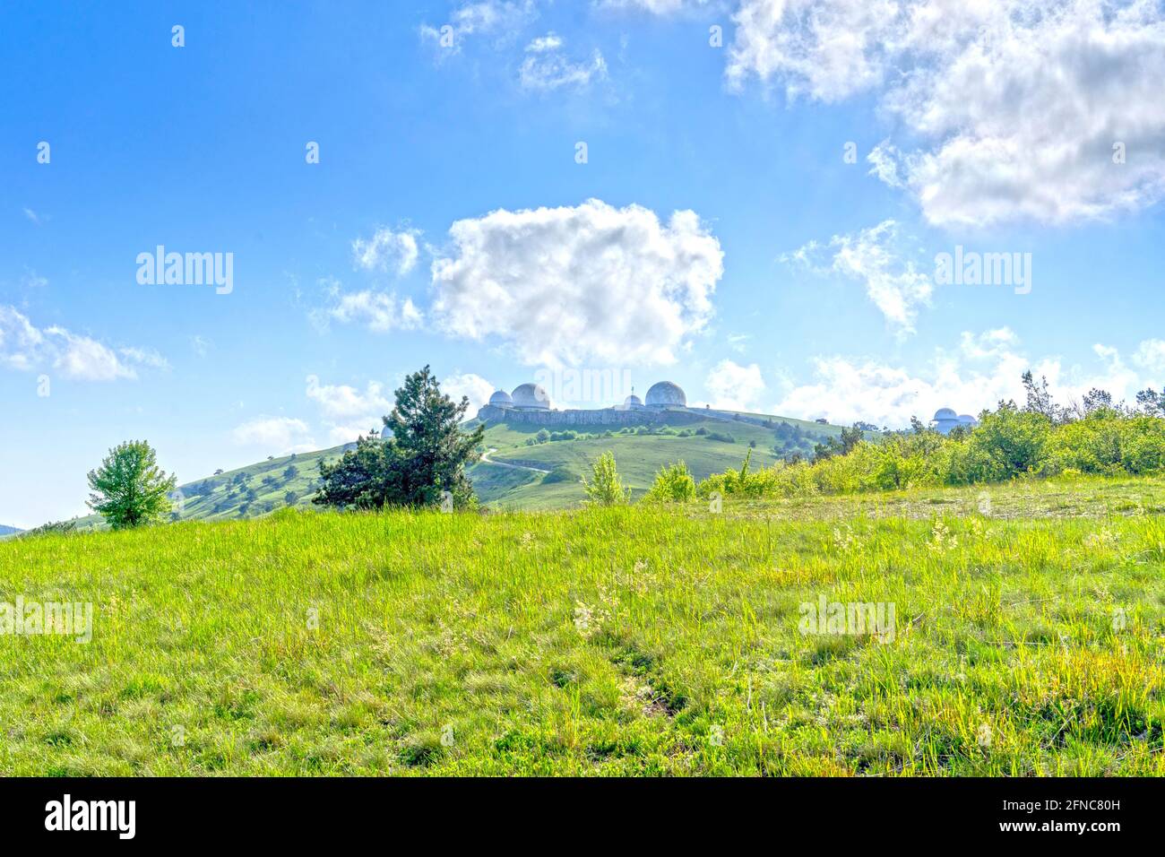 Landschaft mit Hügeln mit grünem Gras bedeckt. Stockfoto
