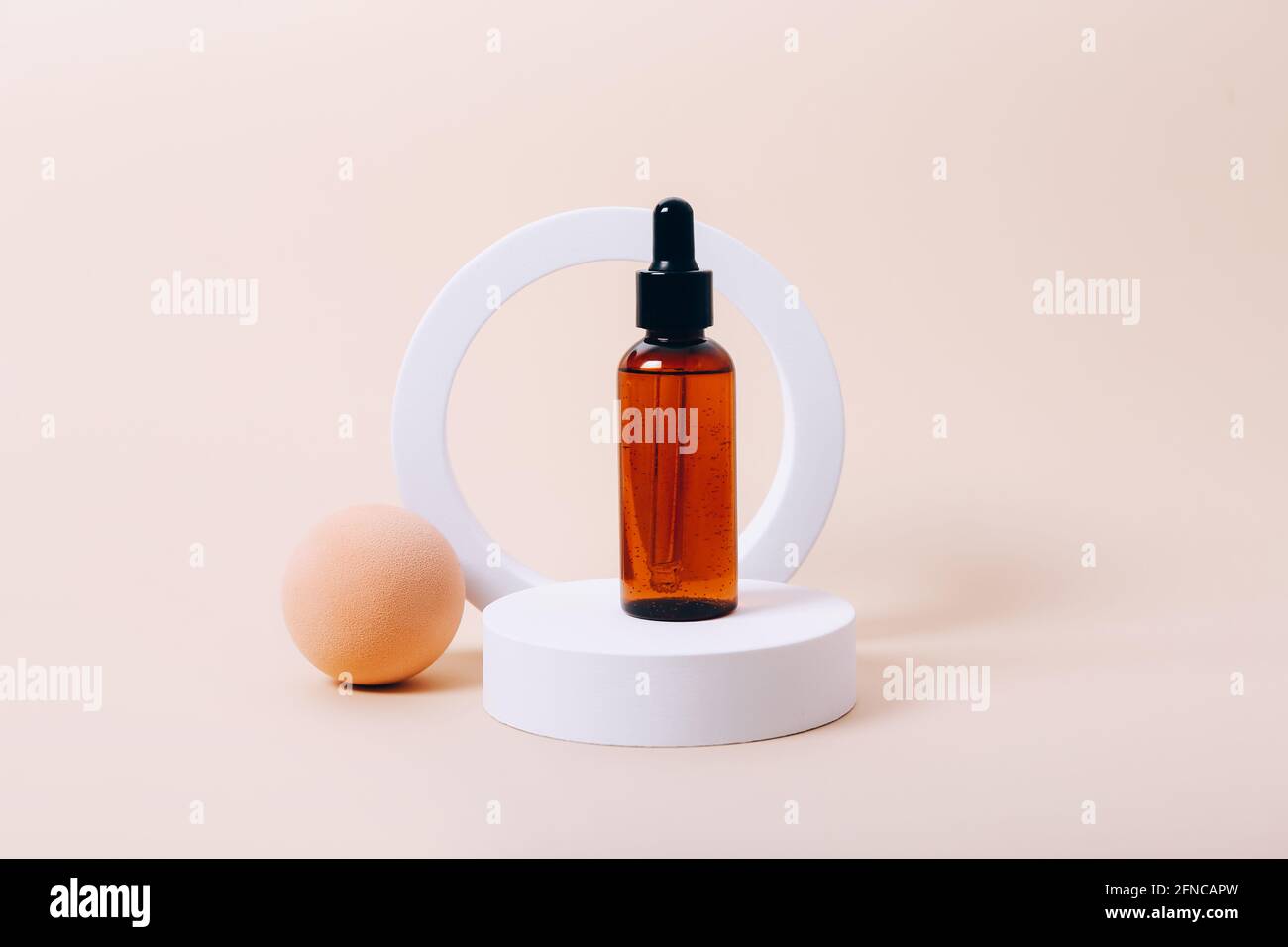 Trendiger Hintergrund mit natürlicher Kosmetik-Hautpflegeflasche auf beigem Hintergrund. Produktpräsentation. Stockfoto