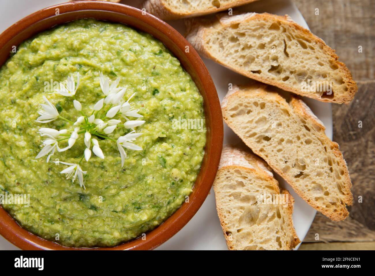 Hausgemachter Hummus, der mit Bärlauch-Blättern, Allium ursinum, verzinnten Kichererbsen, Zitronensaft, gerösteten und zerkleinerten Sesamkörnern, Salz, pe hergestellt wurde Stockfoto