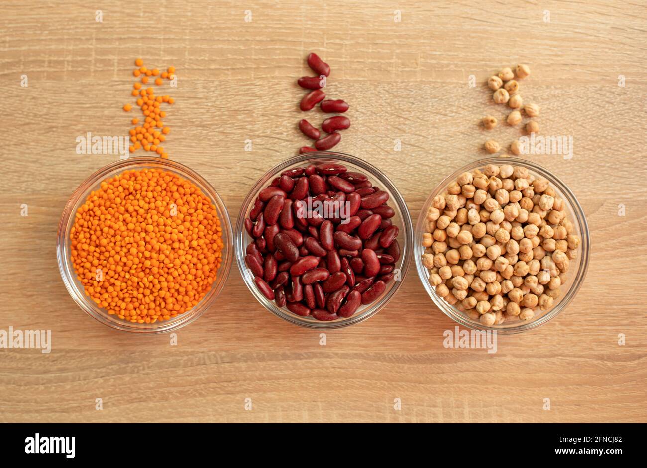 Schüsseln mit Getreidekörnern Kichererbsen, rote Linsen, rote Bohnen Stockfoto