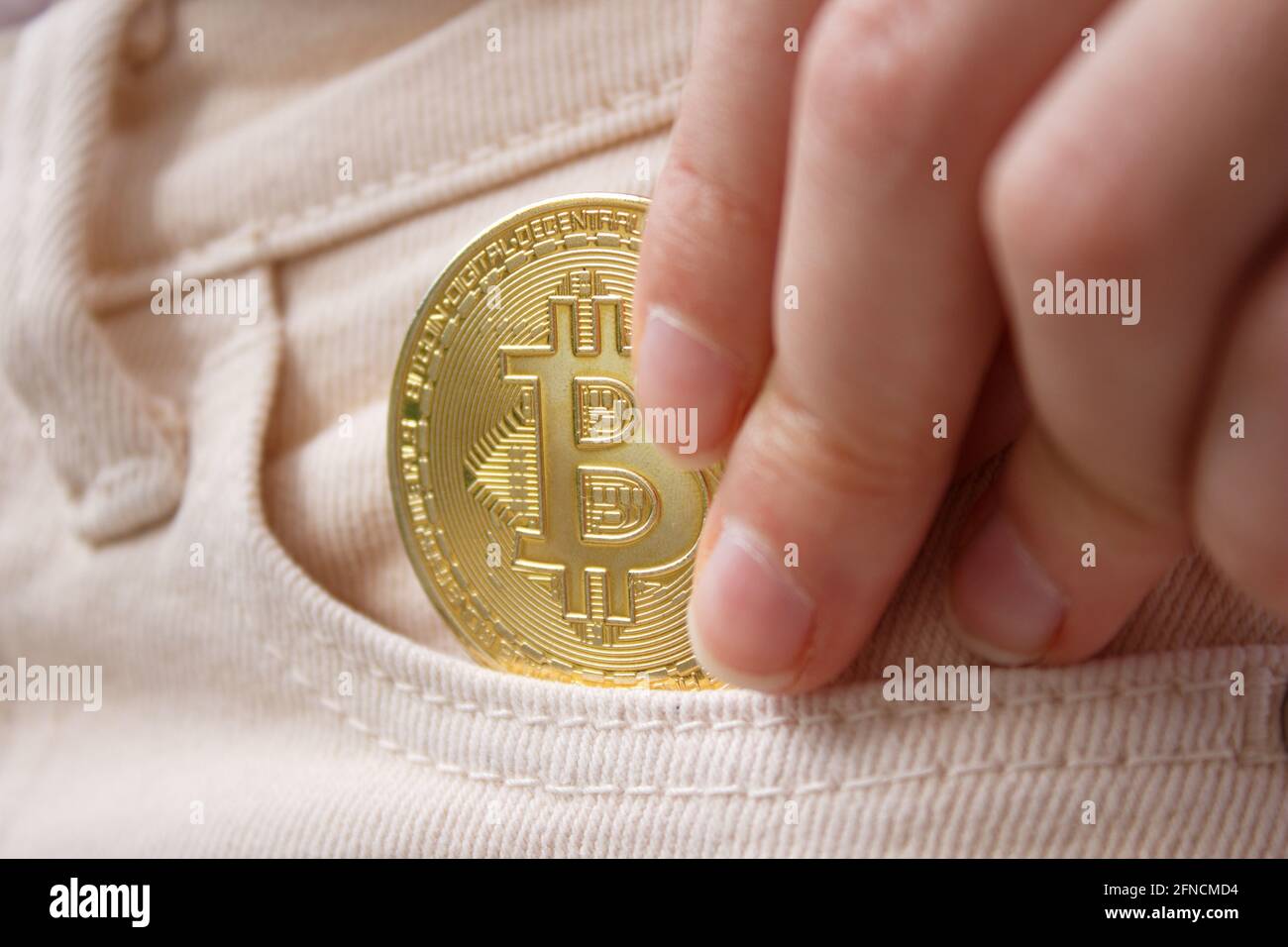 Steckt Bitcoin in der Tasche. Investitionskonzept für Kryptowährungen mit Bitcoin. Stockfoto