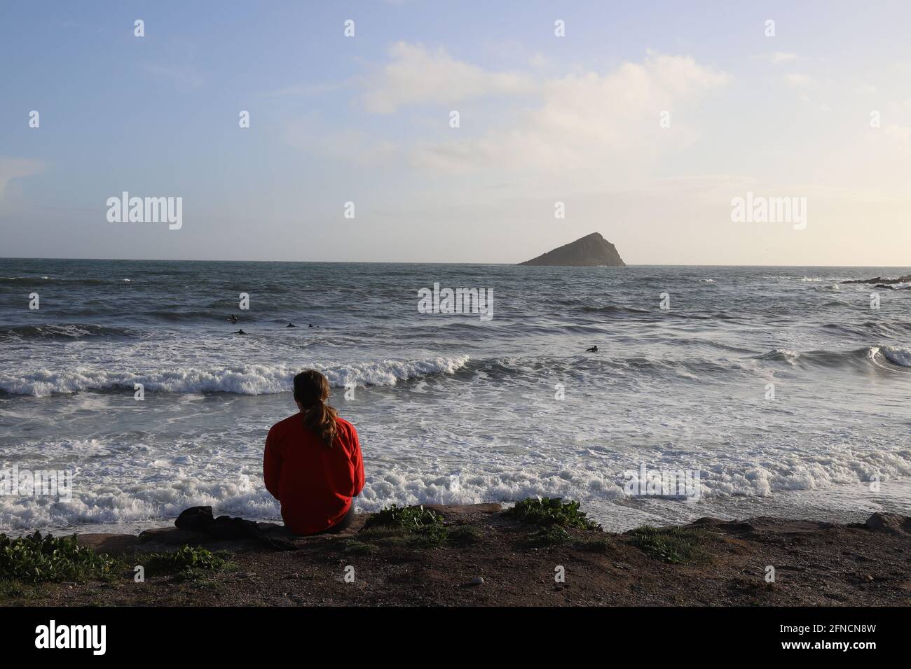 Rückansicht einer Frau mit Blick auf das Meer Stockfoto