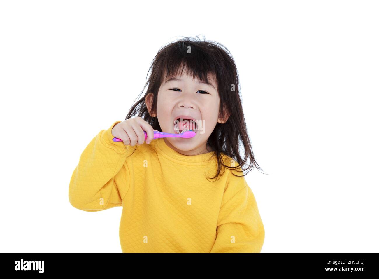 Nettes asiatisches Mädchen im Pyjama mit einer Zahnbürste in der Hand, öffnen Sie den Mund und Zähne putzen, Mundgesundheit Konzept. Isoliert auf weißem Hintergrund. Chinesisches Kind Stockfoto