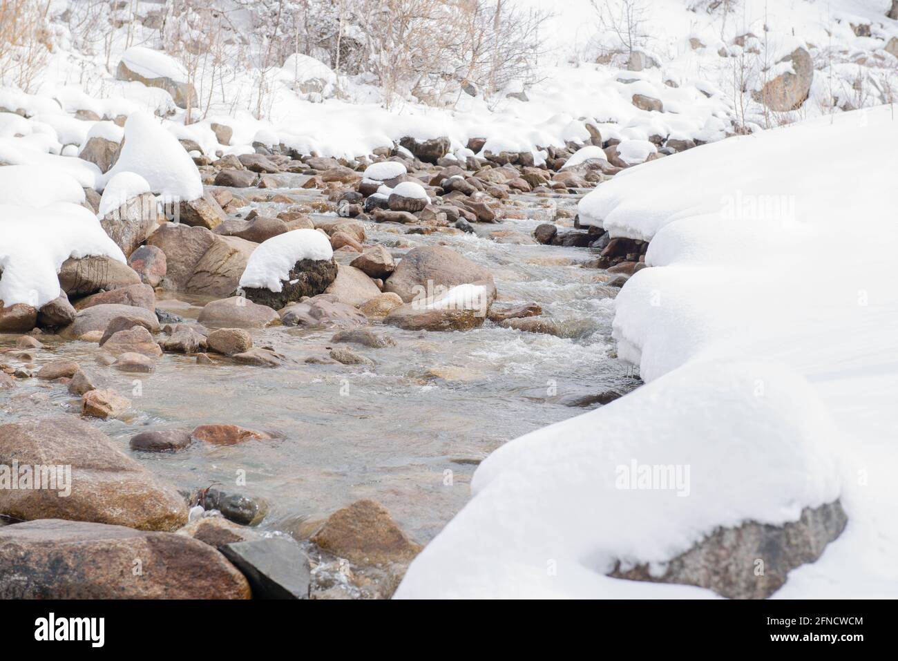 Schöner Fluss mit Steinen im Schnee Stockfoto