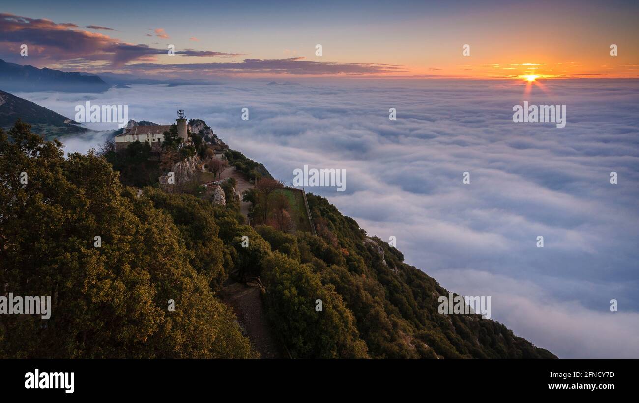 Queralt Sanctuary bei einem Winteraufgang über einem Wolkenmeer betrachtet (Provinz Barcelona, Katalonien, Spanien) ESP: Santuario de Queralt sobre la niebla Stockfoto