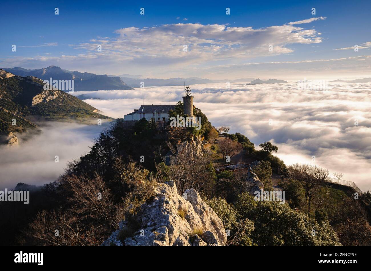 Queralt Sanctuary bei einem Winteraufgang über einem Wolkenmeer betrachtet (Provinz Barcelona, Katalonien, Spanien) ESP: Santuario de Queralt sobre la niebla Stockfoto