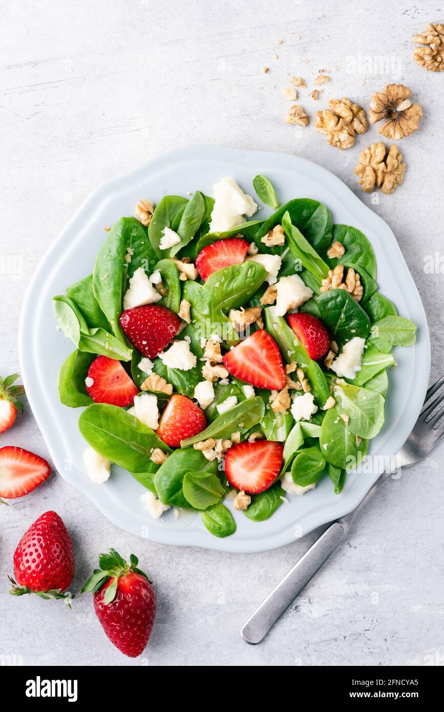 Gesunder Salat mit Erdbeeren, Walnüssen und Käse, Draufsicht Stockfoto