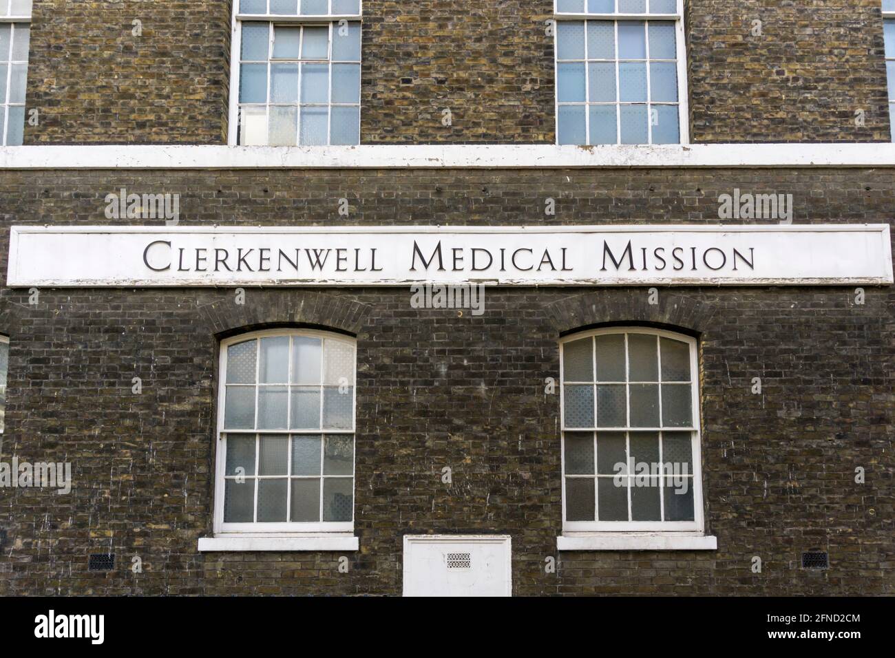 Schild für die medizinische Mission von Clerkenwell an der Seite der Woodbridge Chapel. Stockfoto