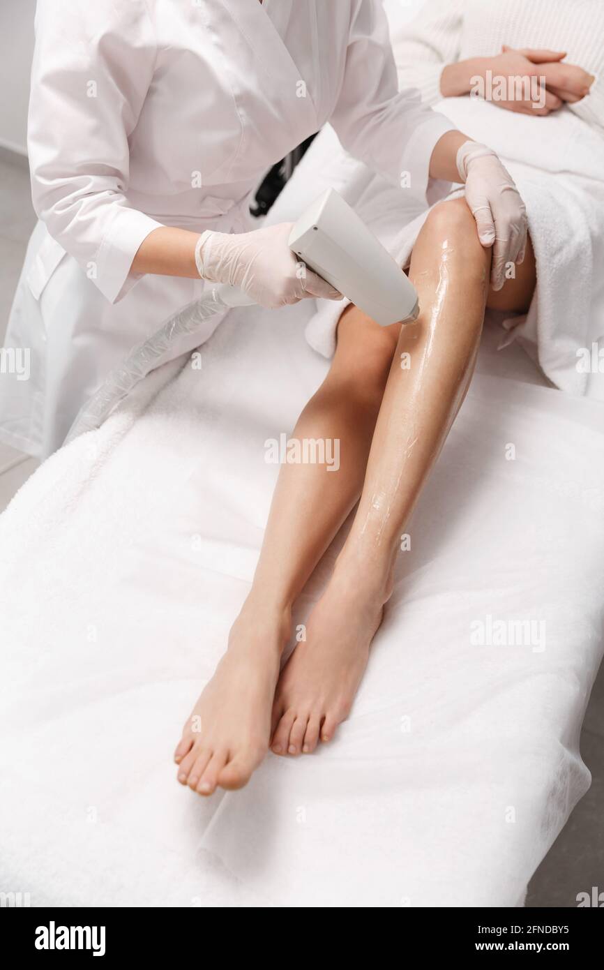 Enthaarung und Beauty Spa-Klinik Konzept. Nahaufnahme von Frauen Beine  bekommen Laser-Haarentfernung Behandlung im Kosmetiksalon, Arzt enthaarten  Bein mit Stockfotografie - Alamy