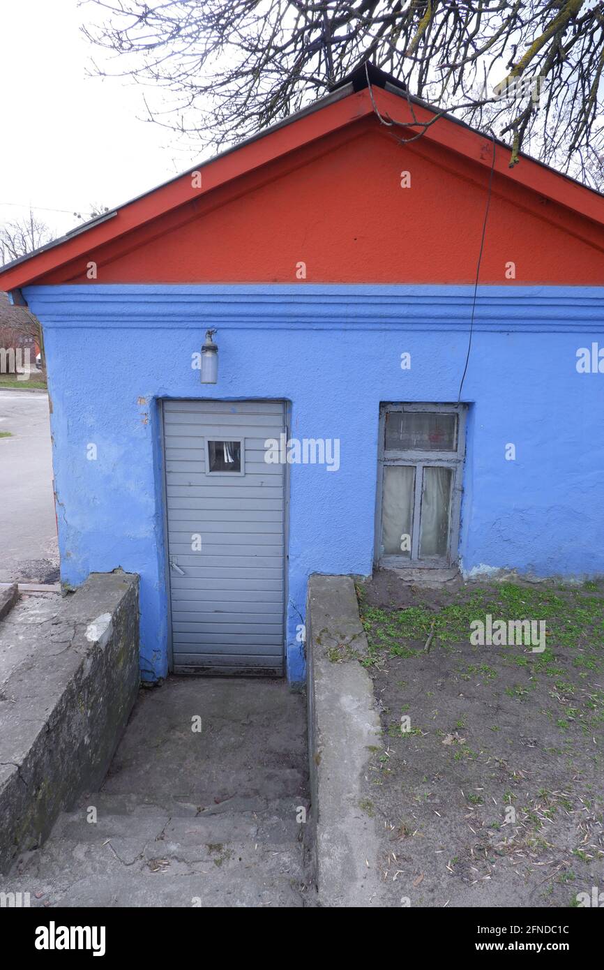 Ein altes kleines blaues Haus mit einem roten Dach in der Stadt. Farbenspiel. Stockfoto