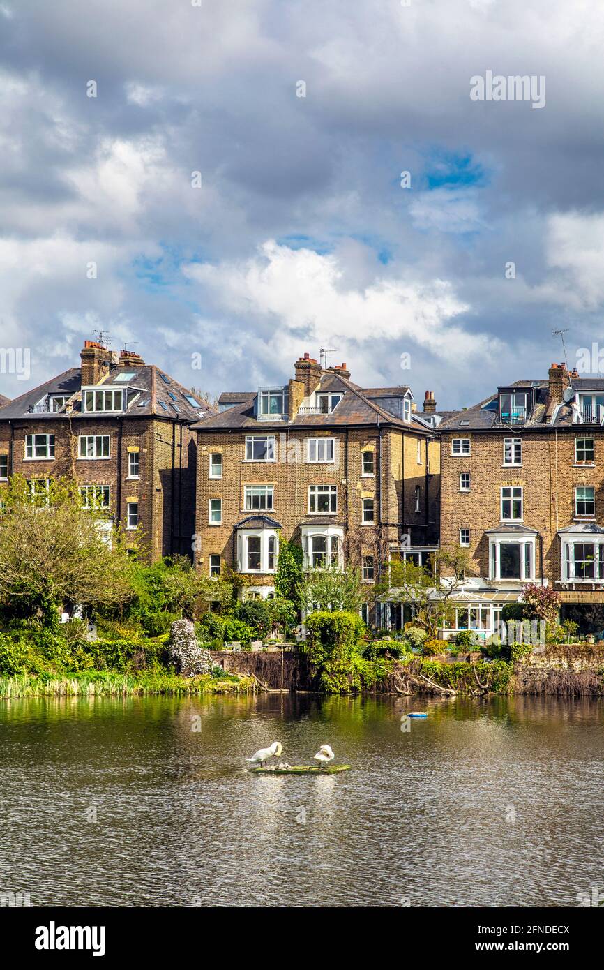Häuser in Hill Park Gardens mit Blick auf einen Teich in Hampseatd Heath, London, Großbritannien Stockfoto