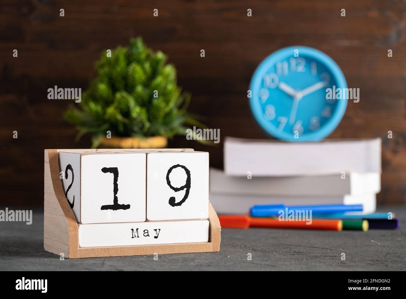 Mai. Mai 19 Holzwürfelkalender mit unscharfen Objekten auf dem Hintergrund. Stockfoto