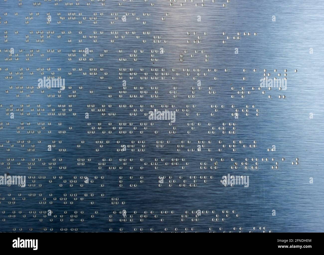 Beispieltext in Brailleschrift auf einer Informationstafel des Parks. Das Foto wurde bei natürlichem Tageslicht aufgenommen. Stockfoto