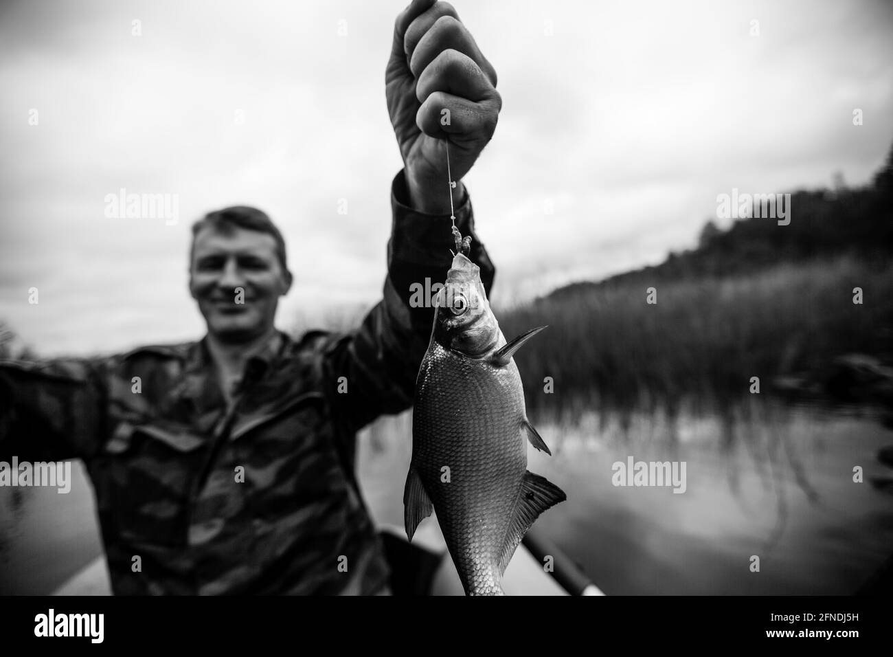 Fischerrute auf dem Fluss auf einem Gummiboot. Schwarzweiß-Foto. Stockfoto