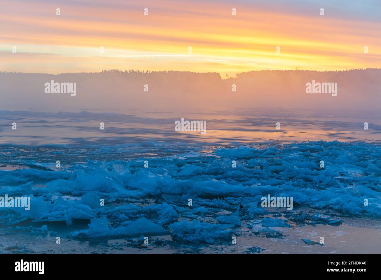 Farbenfroher Sonnenaufgang am eisigen Fluss Stockfoto