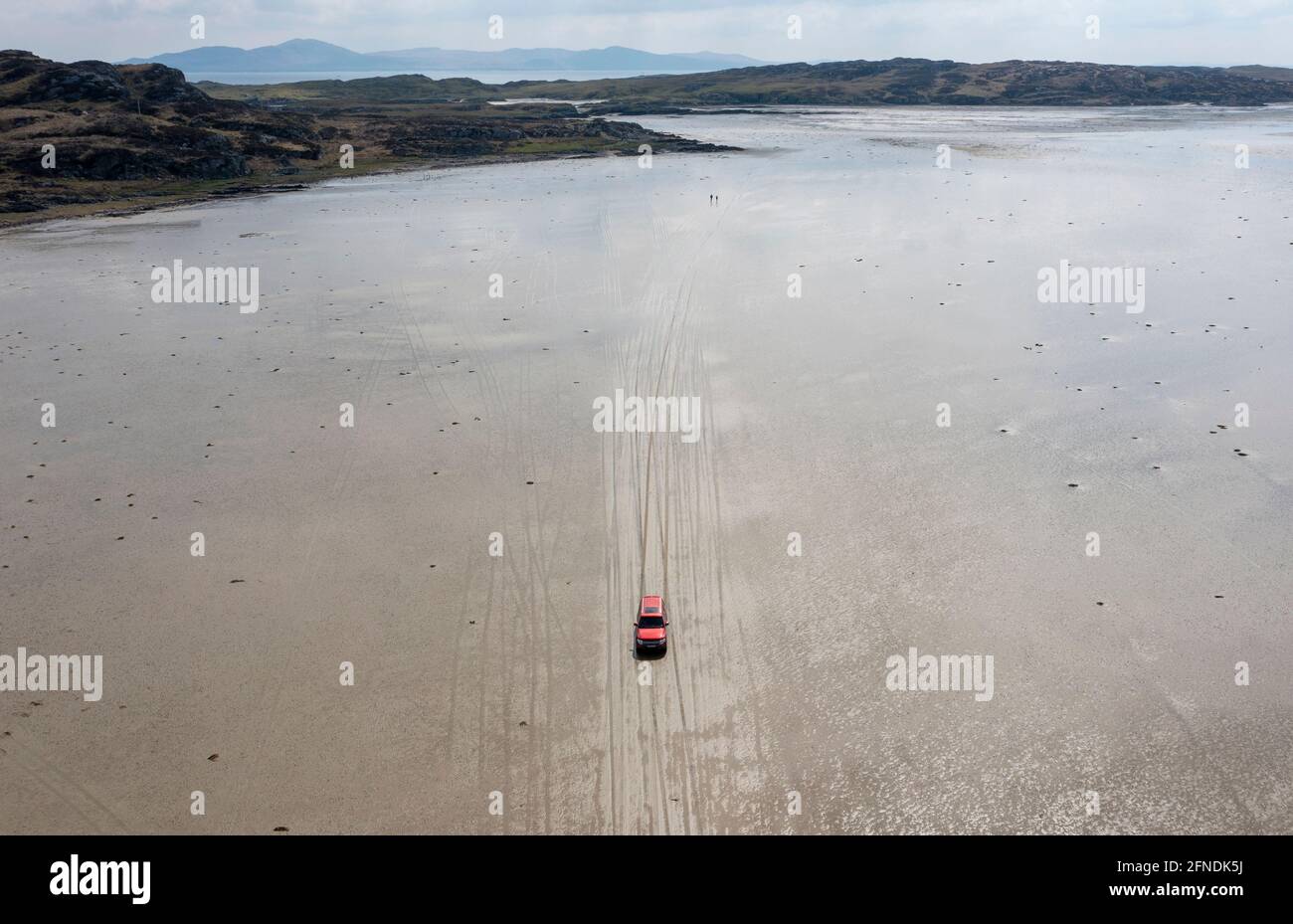 Ein Fahrzeug, das bei Ebbe über den Strand von Oransay nach Colonsay, Inner Hebrides, Argyll & Bute, Schottland, Großbritannien, fährt. Stockfoto