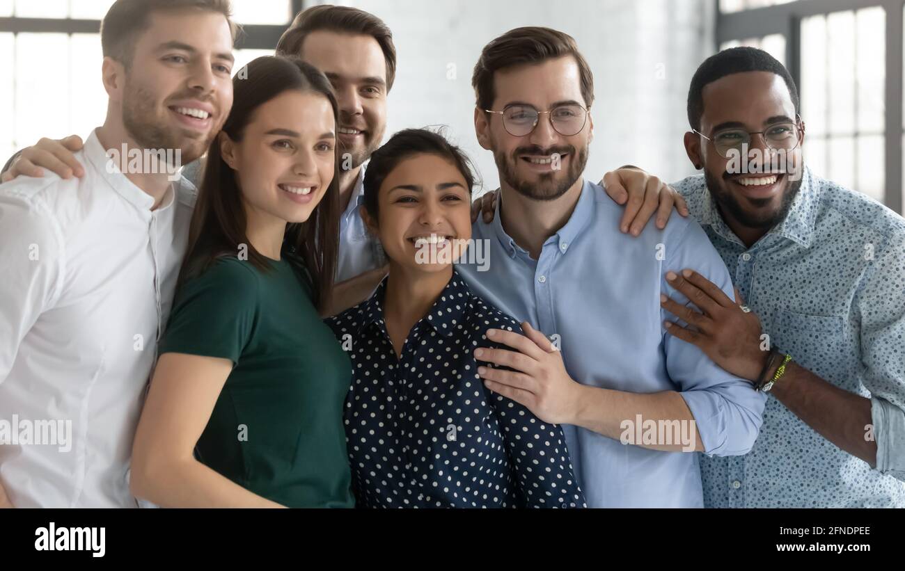 Aufgeregtes Team aus tausenden von Mitarbeitern, das eng beisammen steht Stockfoto