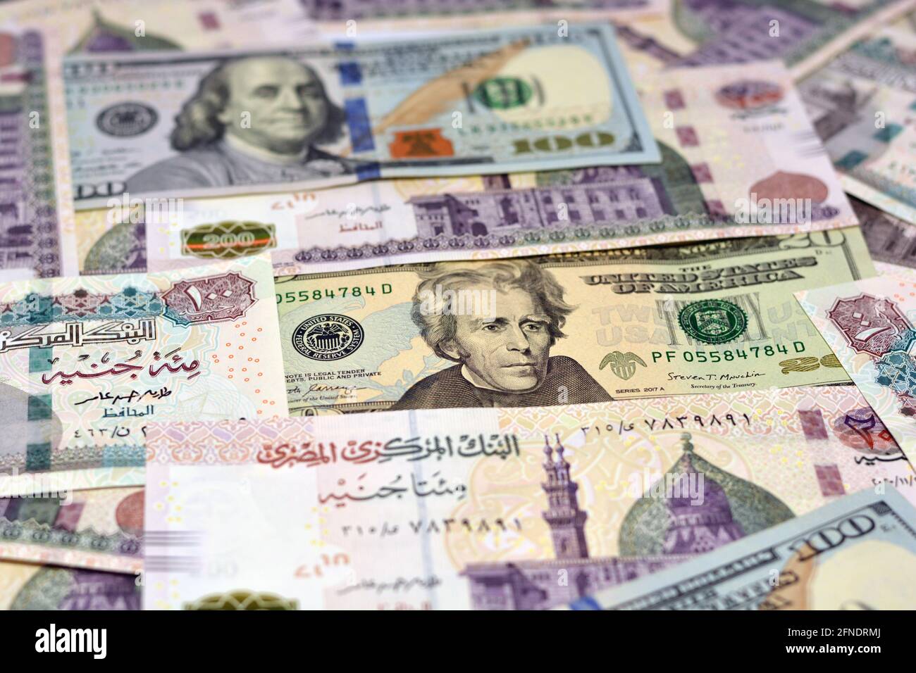Ägyptische Landeswährung mit US-Dollar-Banknoten im Hintergrund. Geldscheine. Ägyptische Pfund-Banknoten und amerikanische Dollar-Rechnungen Hintergrund. Stockfoto
